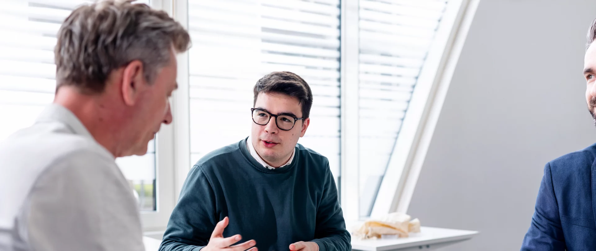Geschäftsgespräch über ISO 42001 und KI-Management in einem modernen Büro.