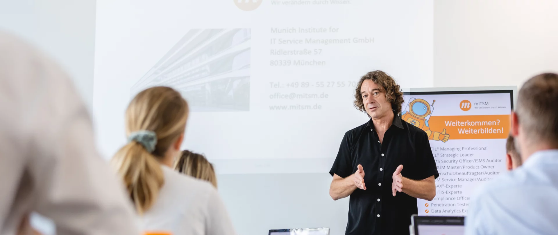 Geschäftsleute bei einer Präsentation zu ISO/IEC 27001 Sicherheitsstandards.